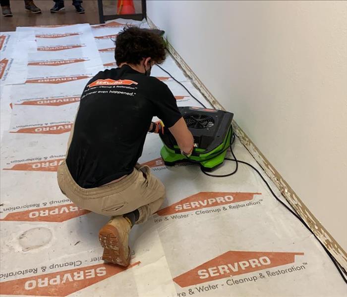 SERVPRO team member is placing a dehumidifier on the floor.